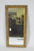 A gilt wood and composition framed wall mirror with pierced border, early C20th, 37 x 76cm