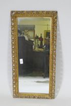 A gilt wood and composition framed wall mirror with pierced border, early C20th, 37 x 76cm