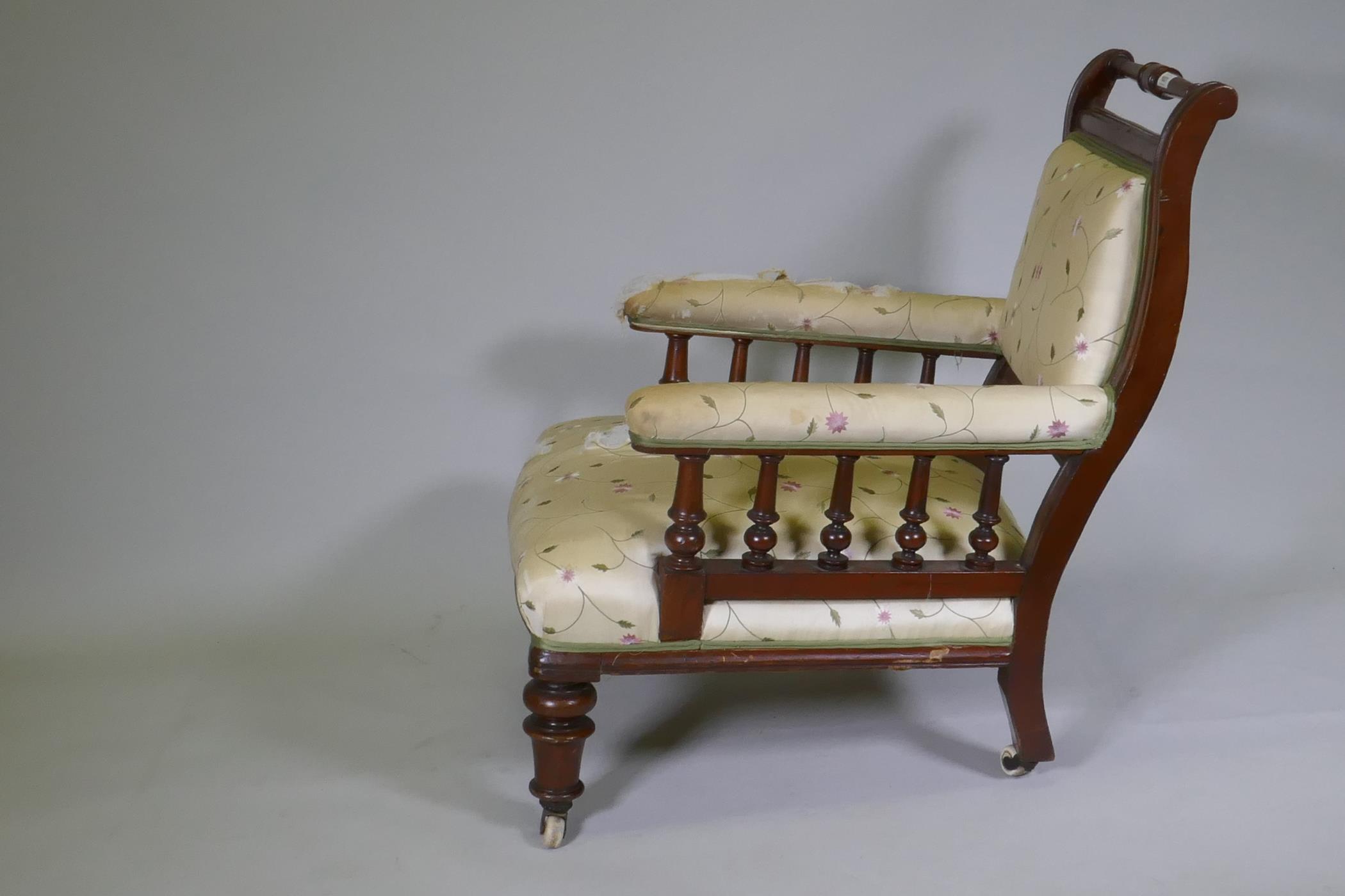 A Victorian walnut show frame easy chair, the open arms with turned spindles, raised on turned - Image 2 of 3