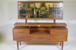 A mid century teak veneer dressing table with floating top, adjustable mirror and five drawers,