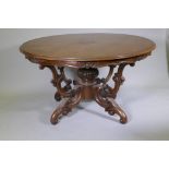 A C19th walnut centre table raised on carved baluster shaped columns and four scrolling supports