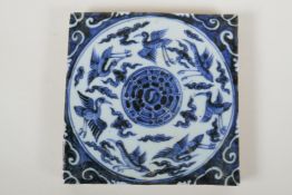 A Chinese blue and white porcelain temple tile decorated with ducks and the yin yang symbol, 20 x