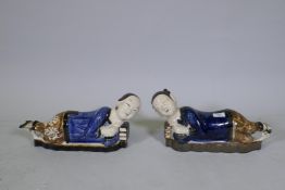 A pair of Chinese ceramic pillows in the form of a recumbent boy and girl, 39cm long