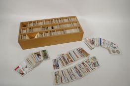 A large quantity of vintage Wills and Players cigarette cards, in a bespoke collectors box