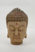 A Chinese carved, painted and distressed wood Buddha head, 21cm high