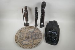 Three African carved hardwood figures, an African carved hardwood wall mask and a soapstone
