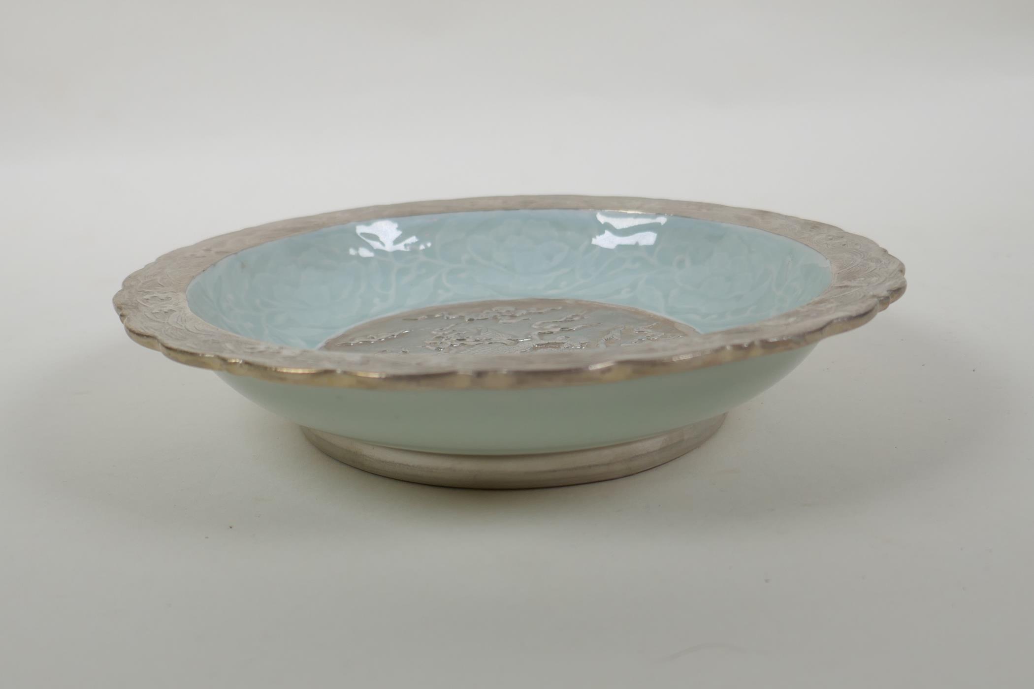 A Chinese celadon and silver glazed porcelain bowl with lobed rim, decorated with a dragon and lotus - Image 3 of 5