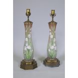 A pair of opaline glass table lamps with hand painted enamel decoration, raised on metal bases, 56cm