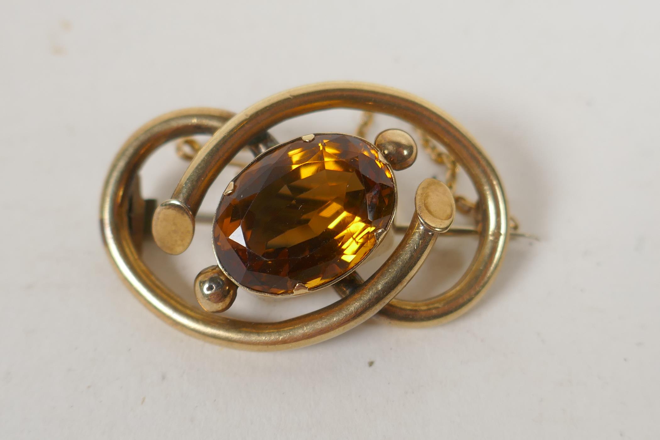 An antique yellow metal brooch set with a large citrine stone, 11g groos