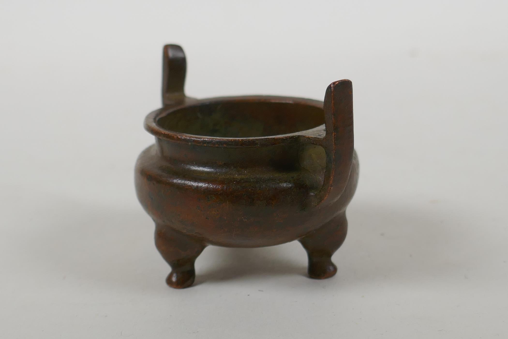 A Chinese bronze two handled censer raised on tripod supports, Xuan character mark to base, 5cm - Image 2 of 4