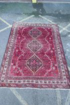 A Persian washed red ground full pile Qashqai tribal carpet, 216 x 294cm