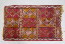 A Turkish red and yellow ground rug with geometric design, 125 x 74cm