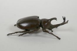 A Japanese style bronze okimono rhinoceros beetle, 9cm long