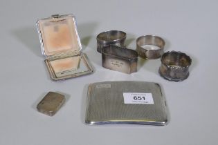 A hallmarked silver cigarette case, compact, pill box and four napkin rings, 259g