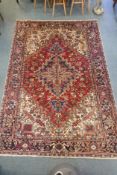 An antique Persian red and cream ground Heriz full pile carpet with black borders, 210 x 296cm