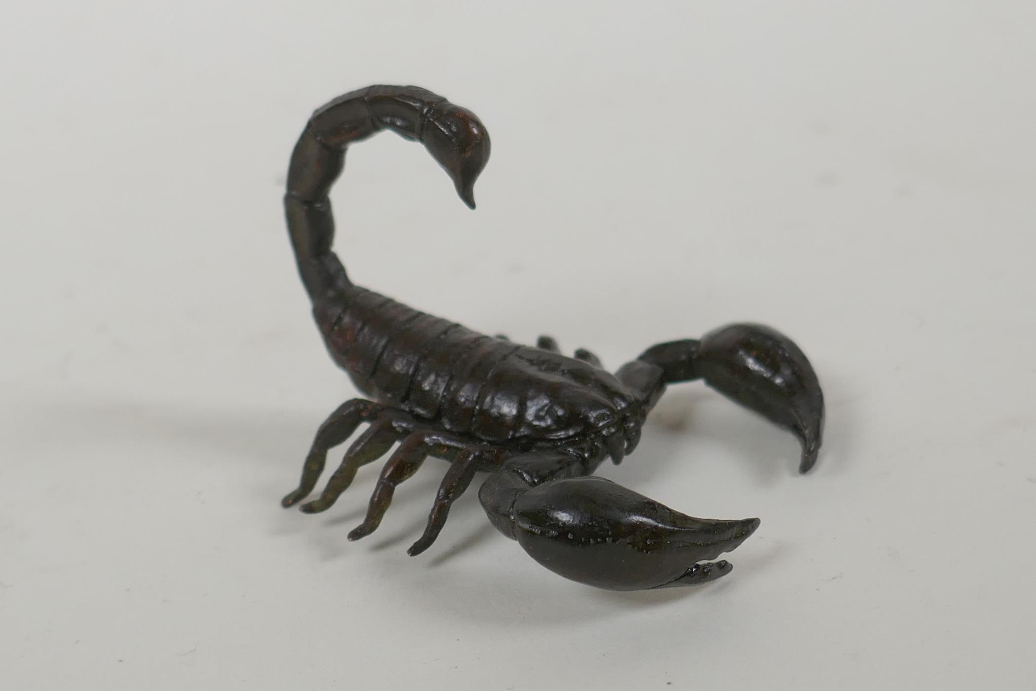 A Japanese style bronze okimono scorpion, indistinct mark to base, 5cm long