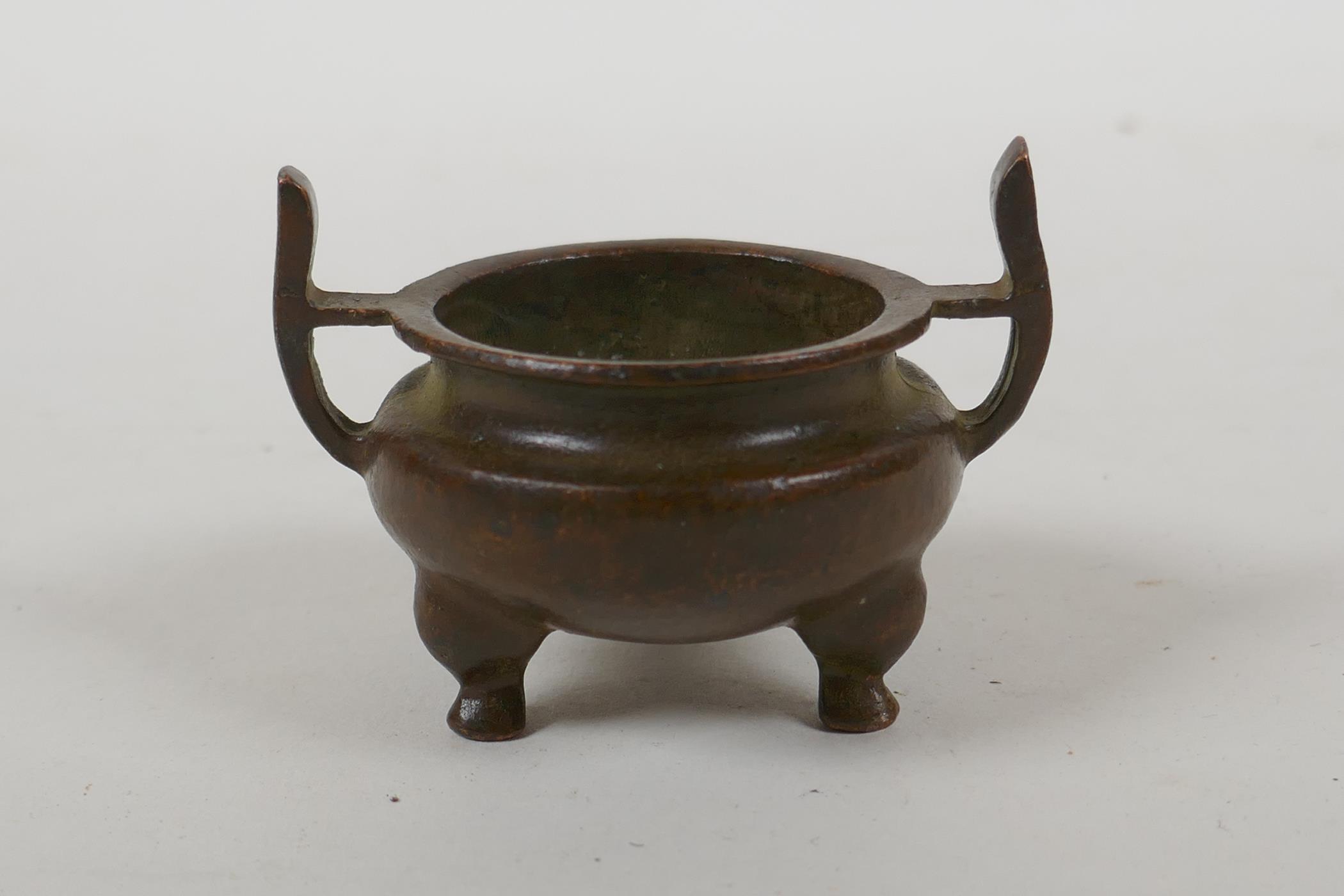 A Chinese bronze two handled censer raised on tripod supports, Xuan character mark to base, 5cm - Image 3 of 4