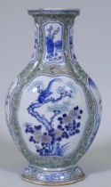 An antique Chinese lozenge shaped vase, with famille verte decoration and raised panels painted with