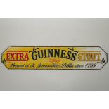 A cold painted cast iron 'Guinness Extra Stout' sign, 56cm long