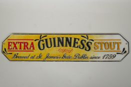A cold painted cast iron 'Guinness Extra Stout' sign, 56cm long