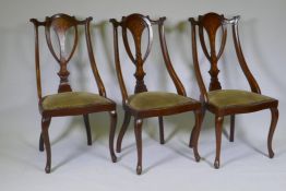 A set of three Victorian inlaid mahogany parlour chairs, raised on cabriole supports
