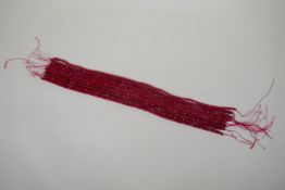 Nine bead strings of faceted ruby coloured hardstone, assorted sized strands, 39cm long