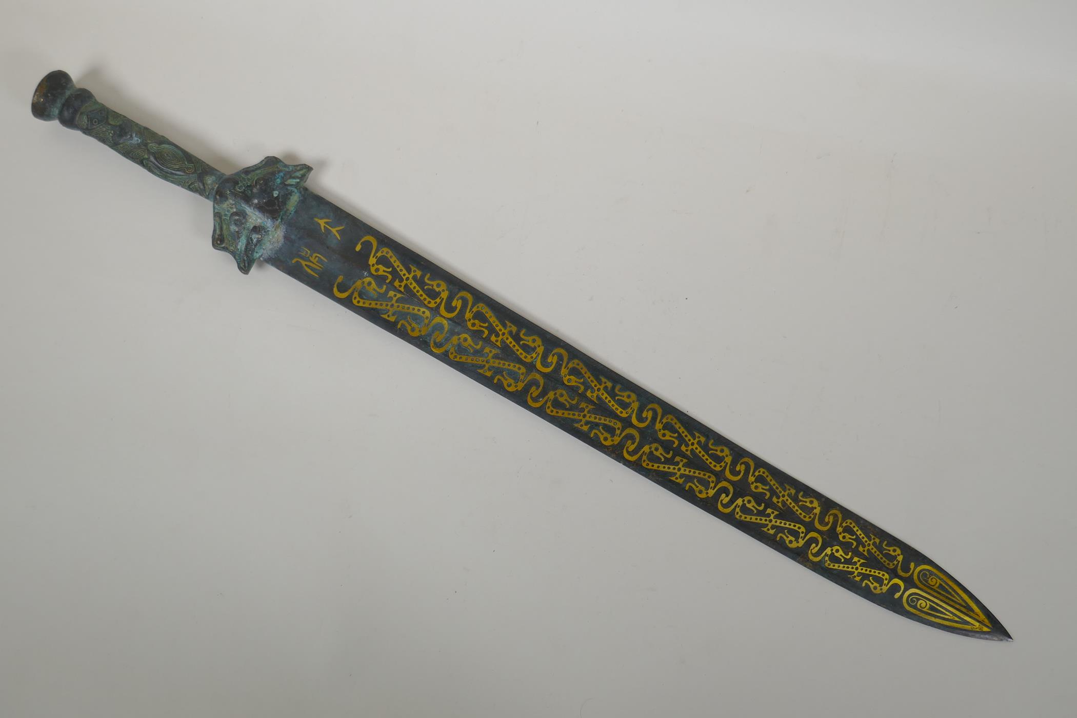 An archaic style Chinese bronze short sword with stylised dragon decoration, 63cm long
