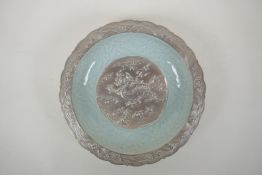 A Chinese celadon and silver glazed porcelain bowl with lobed rim, decorated with a dragon and lotus