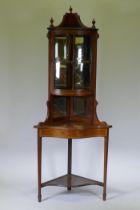 A Victorian mahogany corner display cabinet with single bow front glazed cupboard, mirror back and