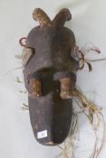 An antique African tribal carved wood zoomorphic mask with painted decoration, 56cm high