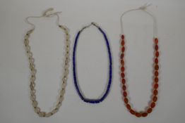 A graduated lapis bead necklace, a string of graduated agate beads and a string of graduated crystal