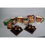 A set of six Royal Doulton mask jugs and twelve miniature jugs with display shelves