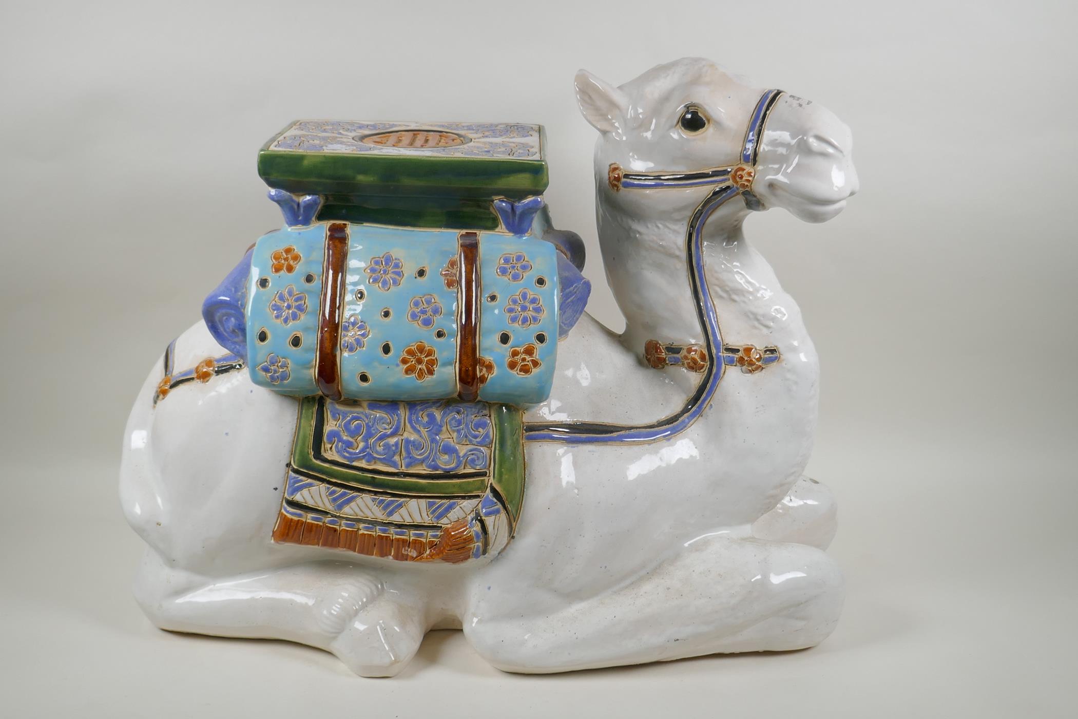 A Chinese ceramic garden seat in the form of a camel, 60cm long, 45cm high