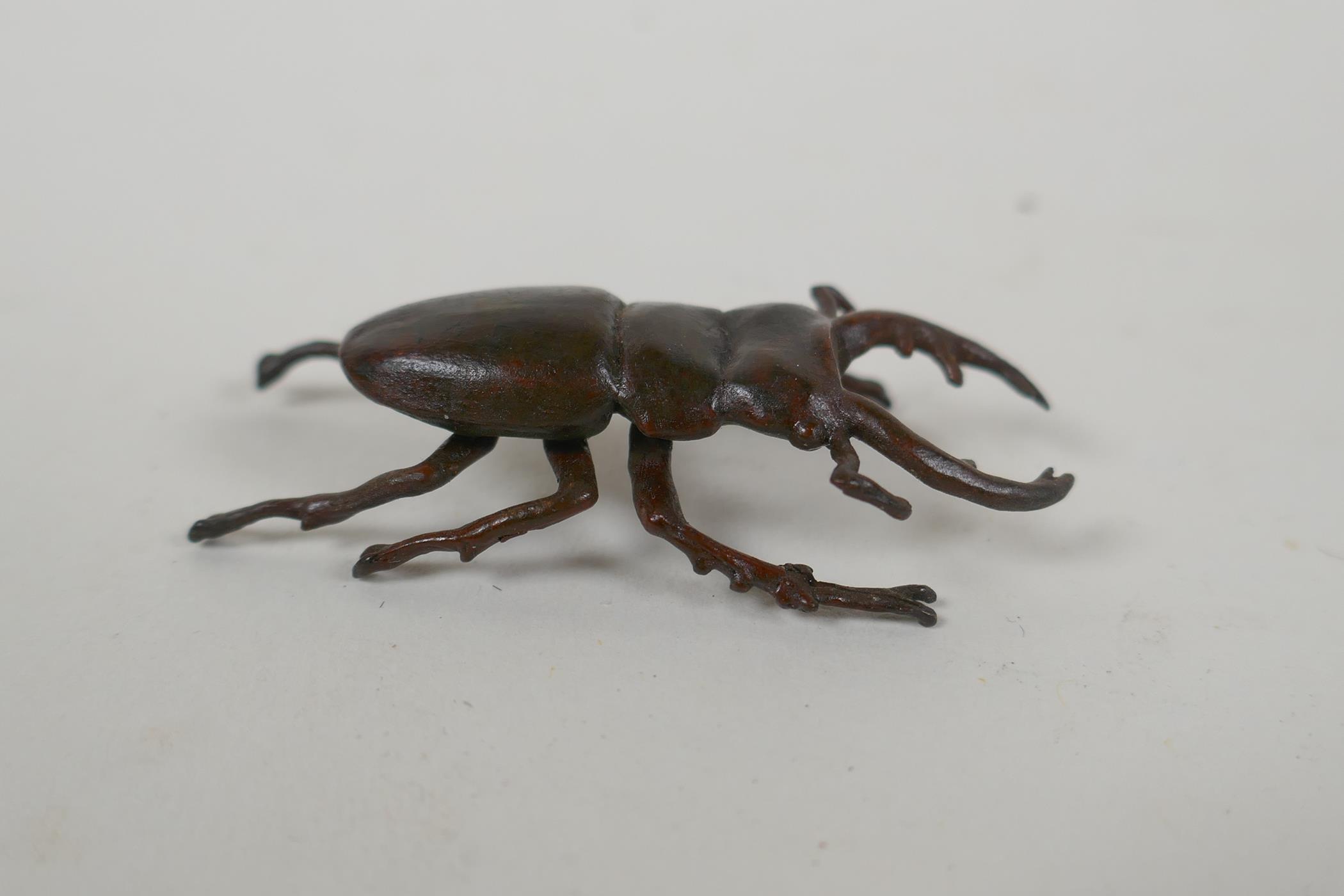 A Japanese style bronze okimono stag beetle, 5cm long