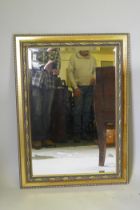 A contemporary gilt wall mirror with moulded decoration, 103 x 76cm