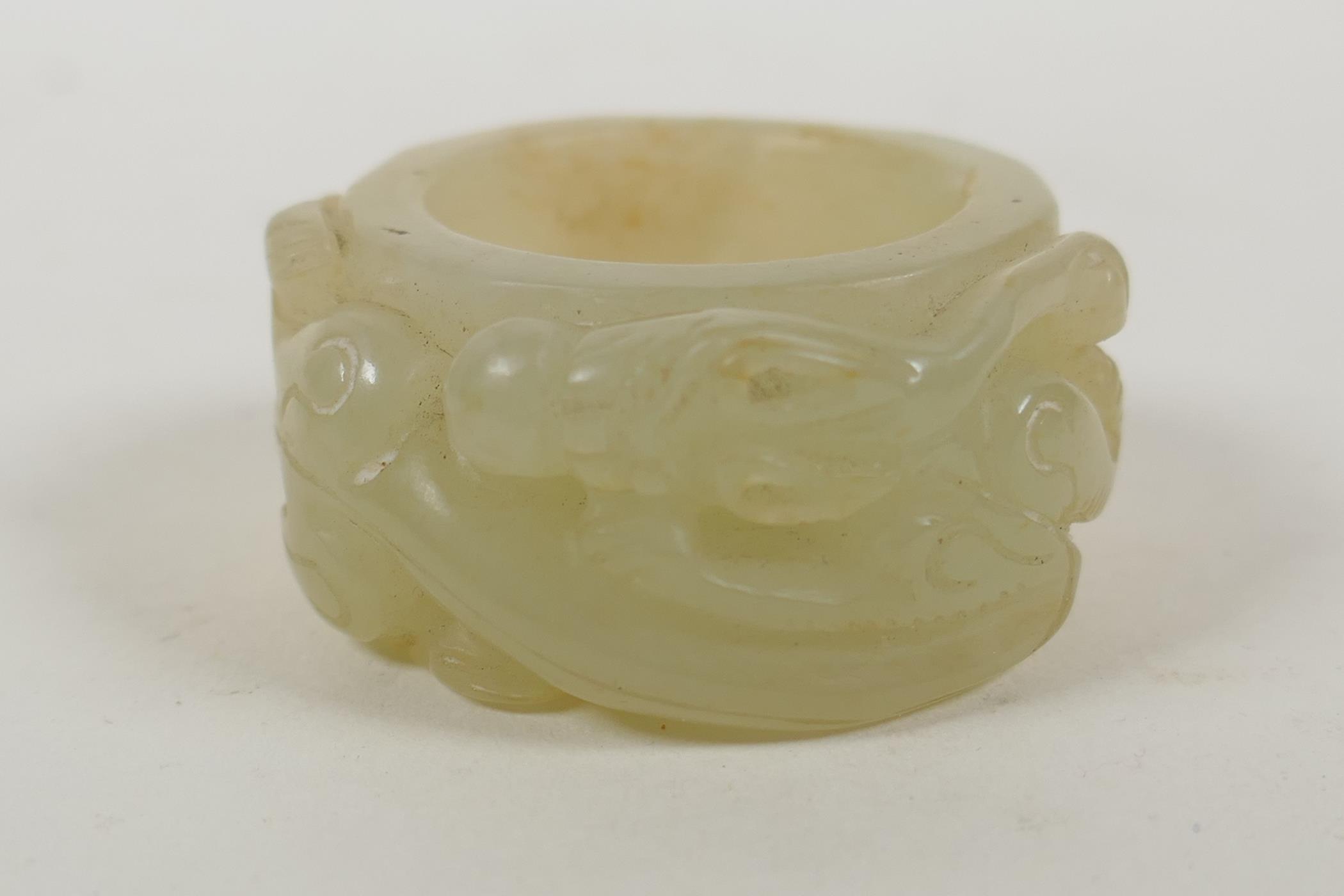A Chinese hardstone thumb ring with carved dragon decoration