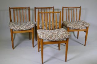 A set of four mid century beechwood and ash dining chairs with saddle style seats