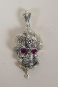 A white metal pendant in the form of a skull entwined with a snake, 6cm drop