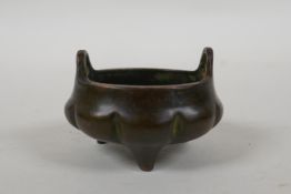 An antique Chinese miniature bronze censer of gourd form with two handles and tripod supports,