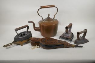 A quantity of antique fireside items to include a copper kettle, cast iron and bronze trivets, irons