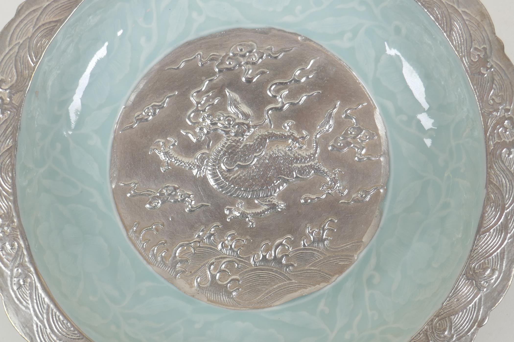 A Chinese celadon and silver glazed porcelain bowl with lobed rim, decorated with a dragon and lotus - Image 2 of 5