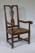 An early Georgian elm elbow chair with vase shaped back splat, drop in seat and raised on square