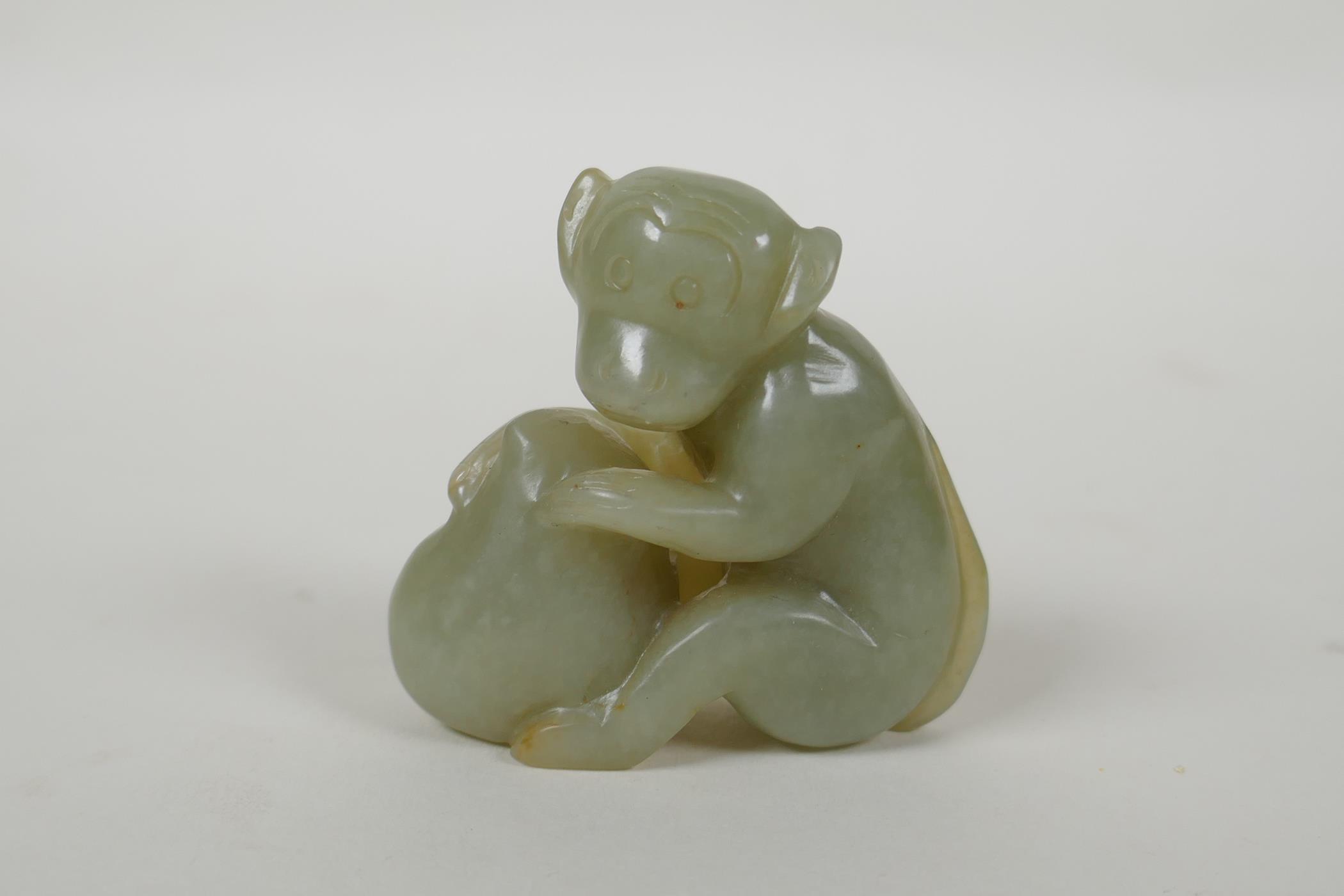 A Chinese carved nephrite jade monkey with a peach, 5cm high