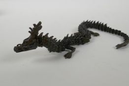 A Japanese Jizai style bronzed metal okimono dragon with articulated parts, 38cm long