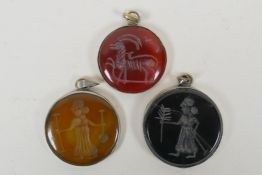 Three Persian white metal pendants set with engraved figural agate intaglio stones, largest 4.5cm