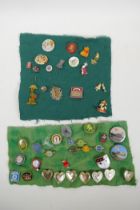 A collection of vintage enamel pins and badges including Disney, Manchester United, Variety Club,