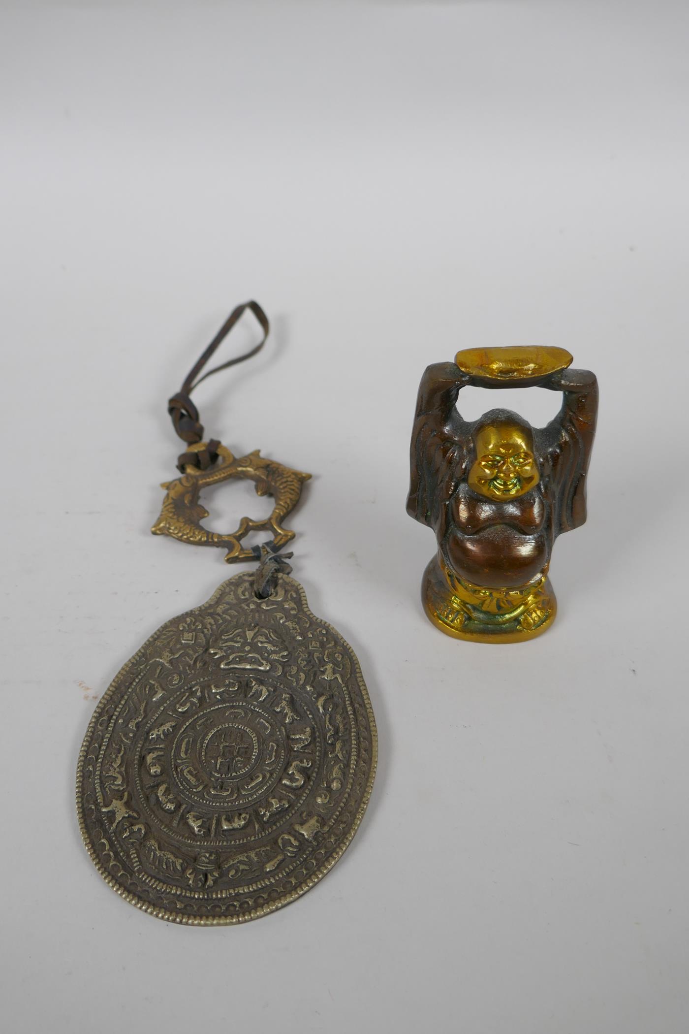 A Tibetan bronze and silvered metal calendar pendant, together with a bronze figure of a jolly