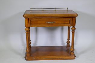 A walnut side table with brass galleried top, single drawer and undertier, united by turned