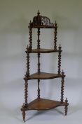 A Victorian figured walnut corner whatnot with four serpentine front tiers united by barley twist