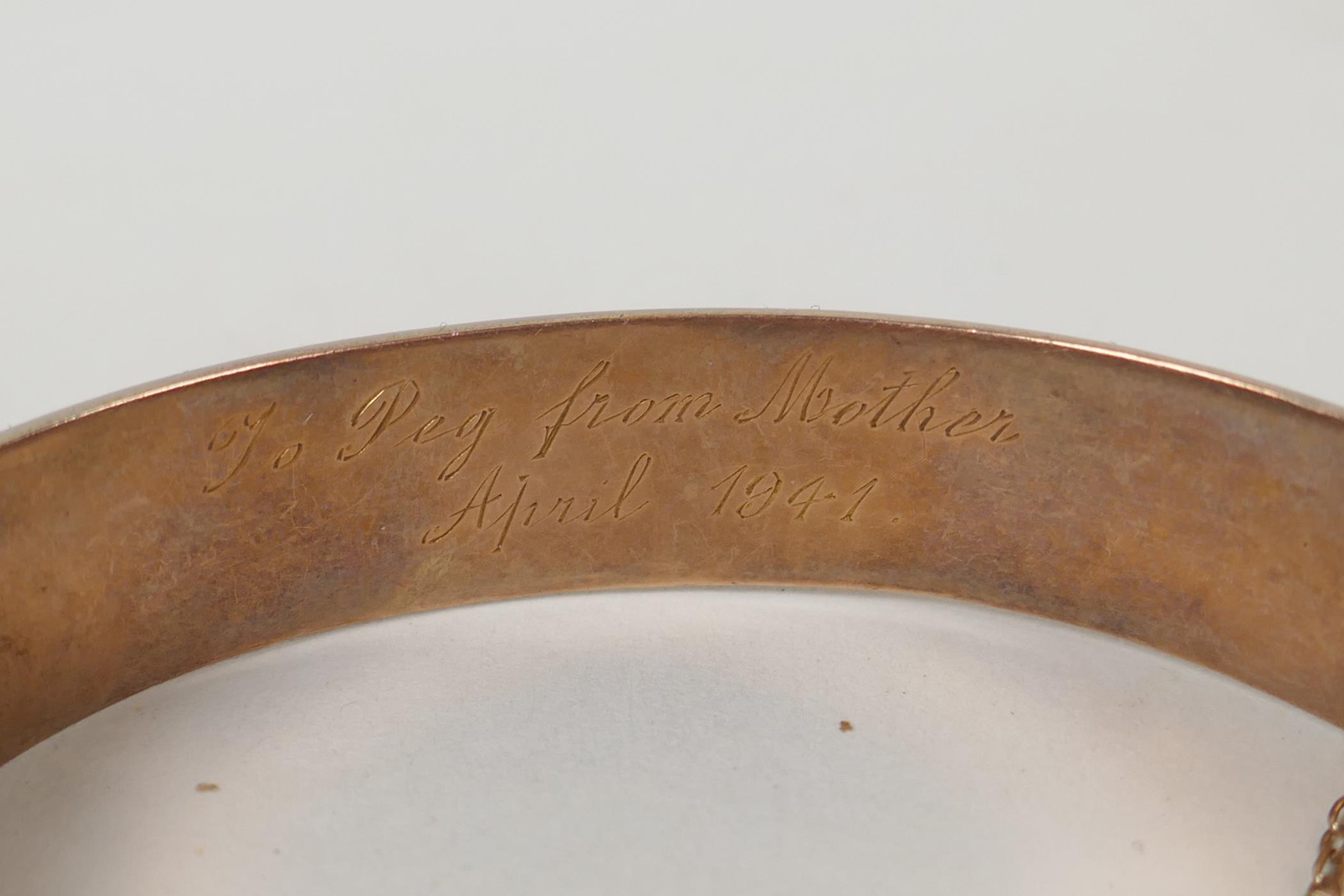 A 9ct gold bangle with scrolling decoration and inscription, 6 x 5.5cm, 14.9g - Image 2 of 3